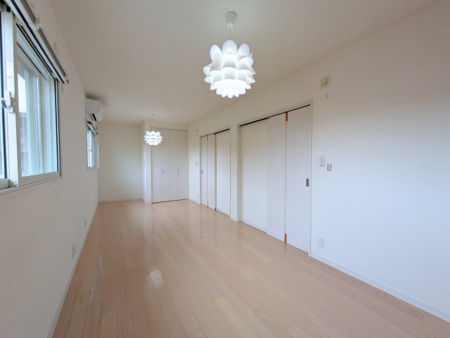 北土居5丁目戸建ての洋室|白い壁と淡い木目の床でまとめた洋室。壁面には複数の扉が並び、すっきりとした印象です。