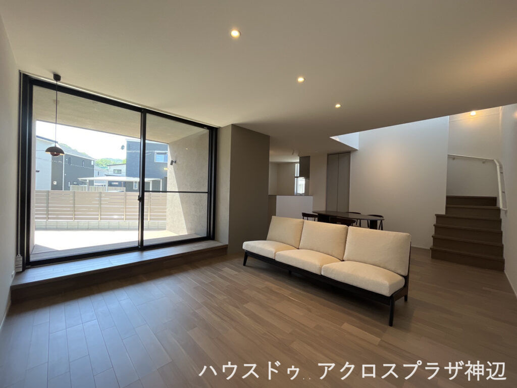 高西町川尻1号棟　3790万の居間・リビング|ビングからフラットに続くウッドデッキ。外からの目線も遮るフェンス付きでプライバシーを守りながら、家族みんながくつろぐことができます。階段上部から心地の良い光が差し込みます。