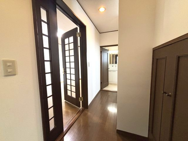 入間市下藤沢 中古戸建の内装|各居室や水まわりへつながる廊下。ガラス入りの室内ドアが空間にアクセントを添え、落ち着いた住まいの雰囲気を演出します。