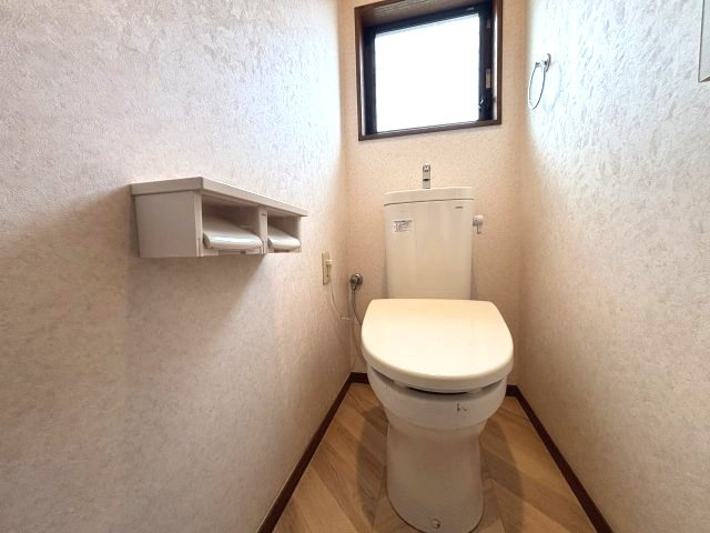 入間市下藤沢 中古戸建のトイレ|窓付きで自然換気ができるトイレ。収納棚も設けられており、トイレットペーパーなどの日用品を整理できます。