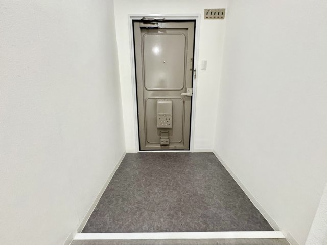 荒神山マンションの玄関|フラットで段差が少なく、小さなお子様やご高齢の方でも安心して出入りできるスマートな設計の玄関です。ゆとりある幅が確保されており、ベビーカーの出し入れや毎日の足元の移動もスムーズに行えます。