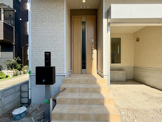 「2階LDKのガレージハウス」高知市城見町第1　1号棟新築一戸建ての玄関|モダンでおしゃれな門柱＆アプローチ。ゆったりとした広さで出入りも安心です。