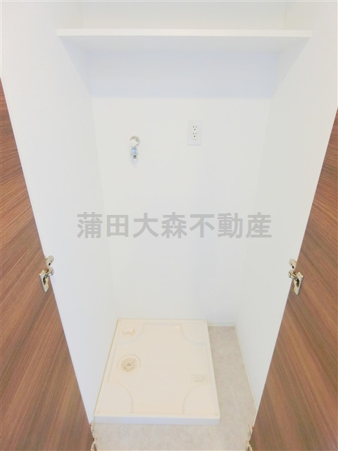 サニークレスト蒲田WESTの設備|扉と棚付きの室内洗濯機置場