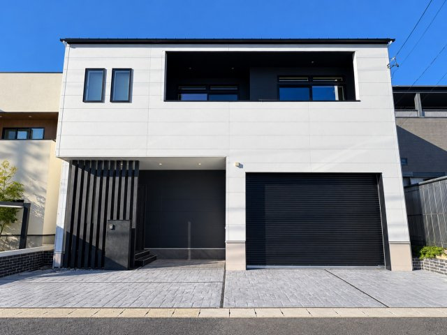 日進市香久山二丁目 戸建の外観|外観｜2025年11月完成。白い外壁と黒の縦格子、シャッター付きビルトインガレージ