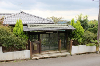 【外観】 | 雰囲気と趣のある玄関から、瓦の母屋の屋根が見えます。実は広大な敷地・建物のごく一部です。