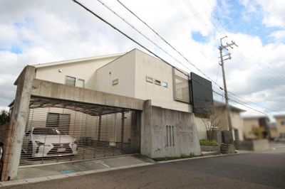 【外観】 | 大津市雄琴北1丁目21-21 建物内に中庭のある戸建て | シャッター付の駐車スペースと窓目隠しがアクセントの建物外観