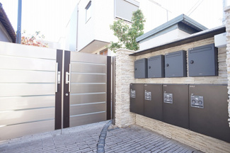 【その他共用部分】 | 建物に入る直前に現れる門扉とポスト。各世帯専用の宅配ボックスも設置しています。