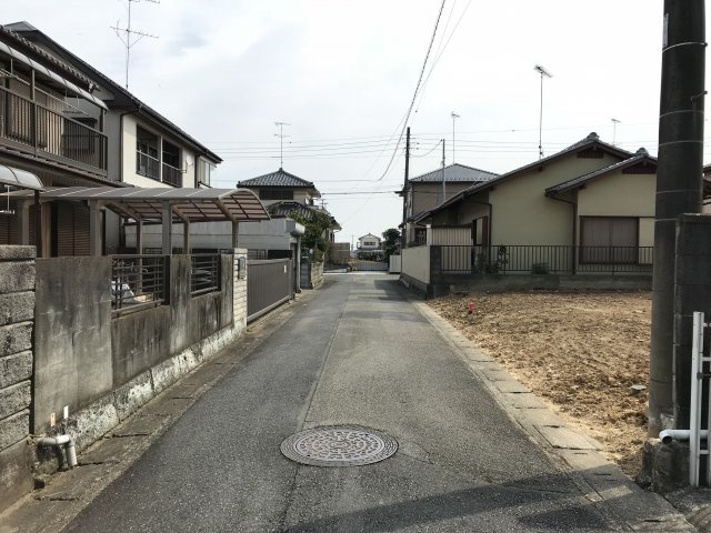 鴻巣市生出塚２丁目の売地の前面道路含む現地写真|写真の右側の白い建物がある敷地が対象物件です。現在は更地です。