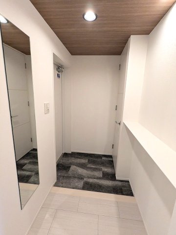 RESIDIA町屋の設備|玄関からは直接室内見えない設計、人感センサー付玄関ライト、姿水鏡、コートフック、棚付きです