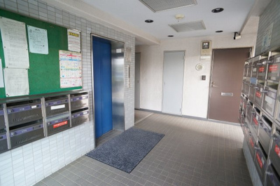 【その他共用部分】 | ルミエール戸田 | エントランスを入るとダイヤル錠付の集合ポストとエレベーター