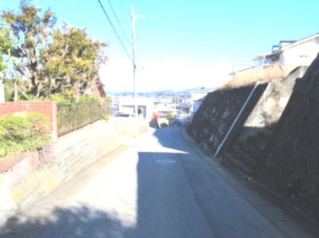 【前面道路含む現地写真】 | 坂田山4丁目（土地） | 西側の接道（道路の南から北方面を撮影）　※右側が物件です（擁壁含む）