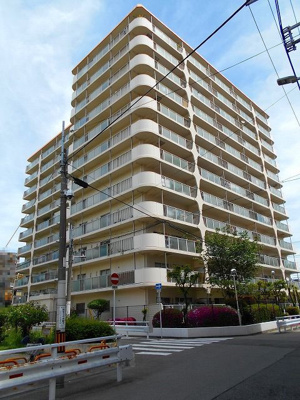 【外観】 | 日商岩井中津マンション | 淡いグレーで配色された外観。手入れの行き届いた植栽が美しい敷地内は駐車場や屋根付き駐輪場、レンガ風のタイルで飾られたエントランスアプローチには、ベビーカーの乗り入れに重宝するスロープ付きです