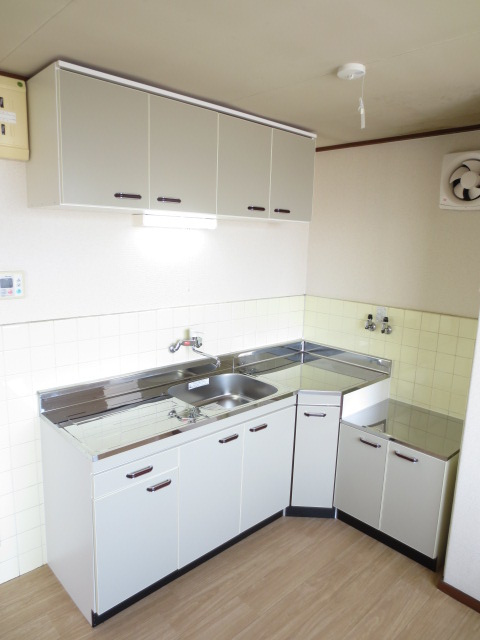 植田マンションのキッチン|L字型キッチン採用。窓付きで換気しやすく作業動線に優れた空間
