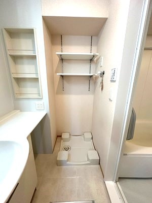 【設備】 | アガイティーラ | 洗面所内、洗髪洗面化粧台横にある室内洗濯機置き場です♪防水パンが付いているので万が一の漏水にも安心です！上部には便利な収納棚付き♪