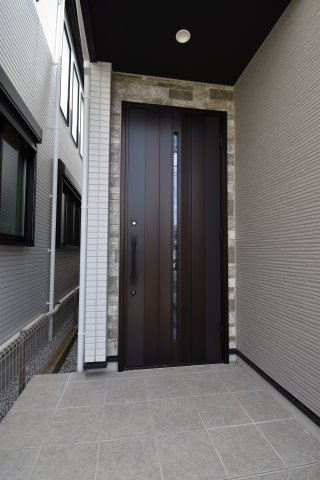 【玄関】 | 杉並区宮前５丁目　新築戸建 | 玄関は重厚感のある扉を採用。スリット状のガラスで玄関内の明るさを確保。