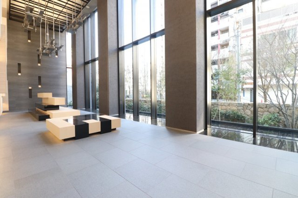 【エントランス】 | 【エントランスホール】屋外の緑景を原寸大で採り入れるガラスウォールで構成されたダイナミックな空間！