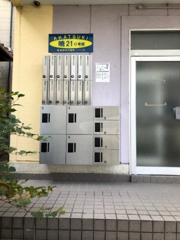 暁21・0号館の外観|建物入口扉横に、ポストと宅配ボックス
