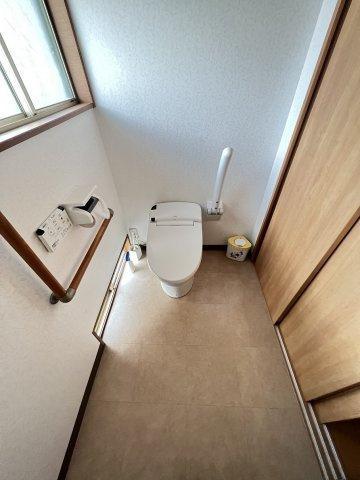 松江町戸建のトイレ|ウォシュレット完備、手すり付きで広々と利用できます。