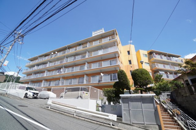【外観】 | セブン牛田（リノベ済） | 【外観】
エントランスには階段がありますが、バス停が目の前の広島牛田早稲田団地郵便局側から入ると、エレベーターホールまで、段差無く入れます。また、本物件全体はV字型をした形状になっています。