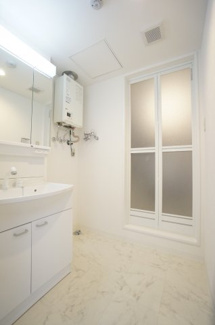 【洗面所】 | グラッツェ櫻乃邸 | ユーティリティへと足を踏み入れると、広々としております。忙しい朝にうれしい洗髪洗面化粧台付です。三面鏡の裏側には収納スペースがあり、化粧品などがすっきり片付きます。