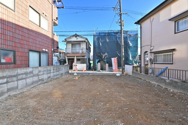 伊丹市鴻池2丁目新築戸建｜自由設計対応の専用収納豊富な3階建て3LDKの外観|現地土地内の北西側中心から前面道路に向けて撮影した現地外観写真です。1街区南側は畑で、4階建て以上の建物が採光を邪魔しない立地です。