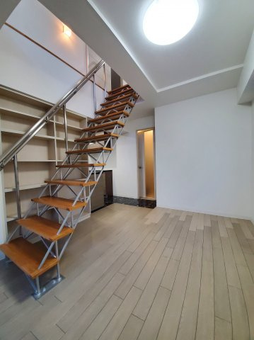 イーストアベニューの居間・リビング|洋室7.5帖、階段横に収納棚あり