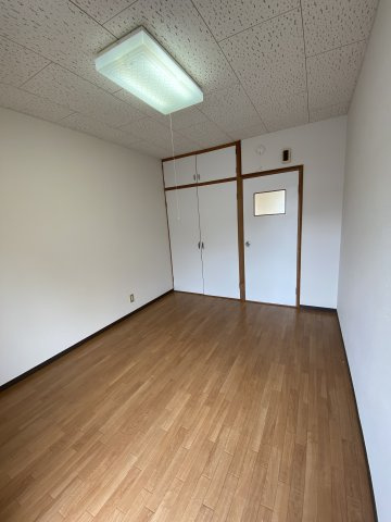 双葉ハイツの洋室|洋室を反対側から見たところです。キッチンとの仕切りドアと収納は白基調。
