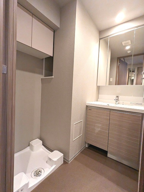 浅草蔵前レジデンスの洗面所|トイレと独立した洗面室です。ハンドシャワー付き3面鏡付き洗面台。洗面台の下にヘルスメーターストックスペースあります