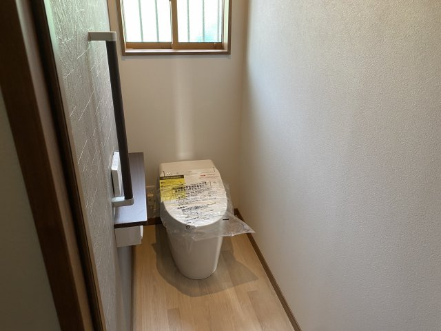 売中古戸建　伊豆市牧之郷のトイレ|トイレには窓があり明るい室内です。手摺がありバリアフリーになっています。
