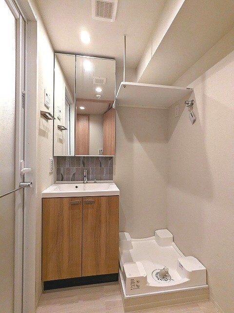 クレヴィアリグゼ日暮里根岸の洗面所|トイレと独立した2面鏡付き洗面室です。排水口のお手入れしやすく排水溝を手前中央に配置し足高の防水パンです
