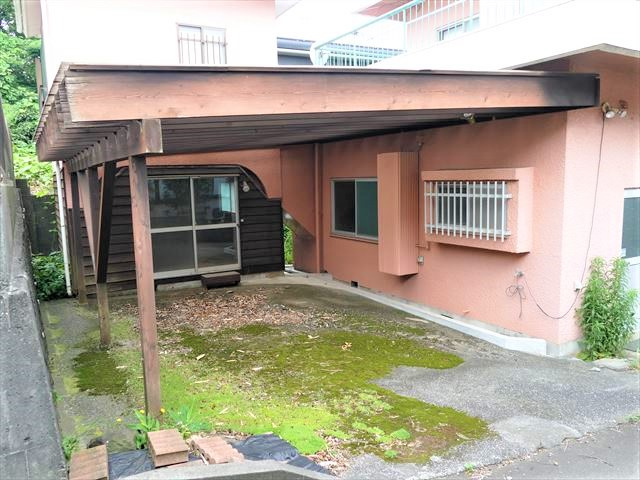 川奈　RC中古建ての外観|裏側にもう一台分駐車スペースが取れます。軒付きの作業スペースとしても。
正面奥は物置スペース