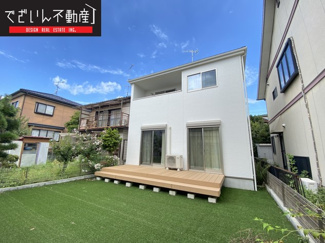 【外観】 | 緑の人工芝に映えるウッドデッキ付きのお家です。
現地(2023年9月撮影)