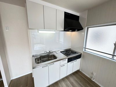 【キッチン】 | リバーハイツ麻生 | 白を基調としたシステムキッチンです！窓があるので換気もOK♪場所を取るお鍋やお皿もすっきり収納できます♪