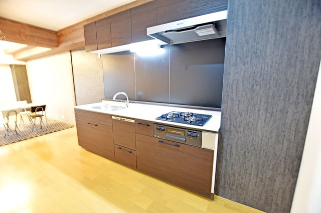 イスズハイツベル夙川公園のキッチン|タッチレス水栓と食洗器を標準搭載しています。天板下いっぱいに収納庫を設けており、調理器具からストック、掃除用具まですっきり収めることが出来ます。