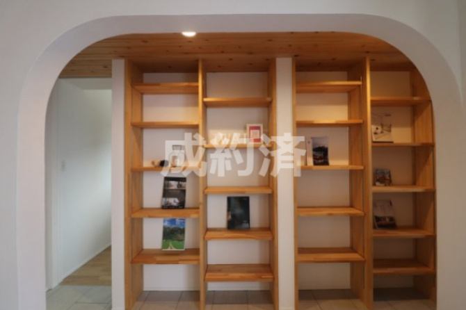 前橋市江木町モデルハウス物件　＃平屋のその他共用部分|曲線アーチの向こうには細かく仕切られた書棚。書籍や雑誌はもちろん写真や作品などのお気に入りを飾って毎日愛でる空間に◎