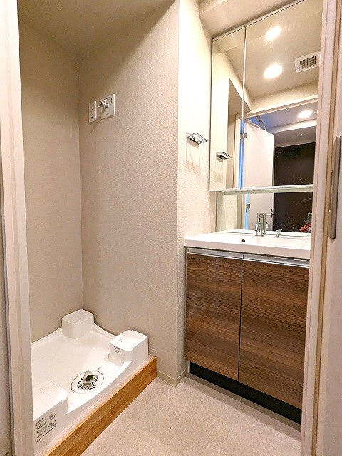 ONE ROOF RESIDENCE ASAKUSABASHIの洗面所|トイレと独立した2面鏡付き洗面台、排水口のお手入れしやすく排水溝を手前中央に配置し更に足高の防水パンです