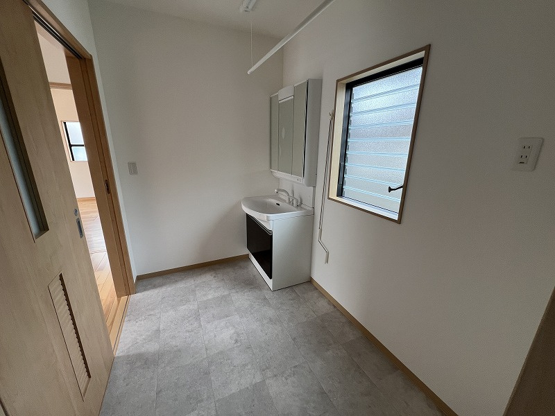 鴨部B号地　中古戸建（未入居）の脱衣所|広めの洗面脱衣場です
タオルなどの収納家具もスッキリ収まります