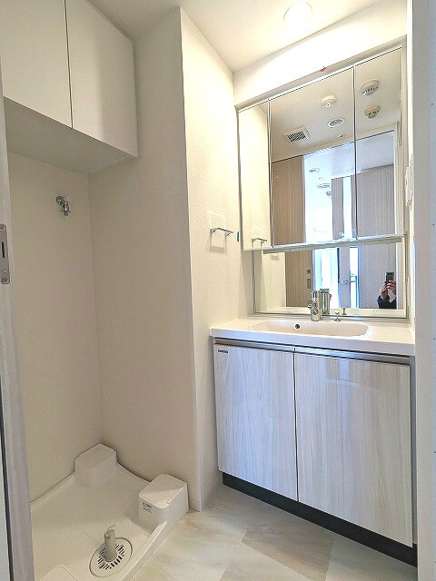 Urbanex KURAMAE RESIDENCEの洗面所|トイレと独立した3面鏡付、ハンドシャワー付独立洗面室、排水口のお手入れしやすく排水口を手前中央に配置した防水パン