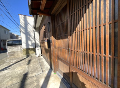 【玄関】 | 伏見区深草下川原町　中古戸建 | 玄関ドアは、大正ロマンを感じる素敵な格子戸。昔懐かしい引き違い戸になっています。