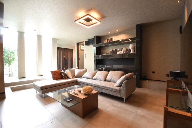 ソトに閉じて、ウチに開く。本物を知るあなただけにの居間・リビング|スキップフロアーのリビングはお客様もゆっくりと寛げる空間となります。バイオエタノール式の暖炉があり、「上質」な空間をお約束します。