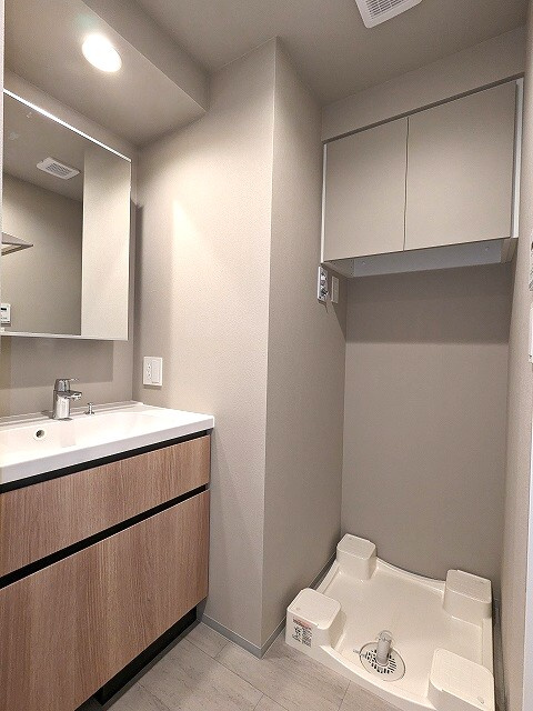 JMFレジデンス蔵前二丁目の洗面所|トイレと独立した洗面室、2面鏡、右下にヘルスメーターストック、お手入れしやすい様に排水口を手前中央に配置し、足高の防水パンです