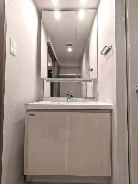 ONE ROOF RESIDENCE上野御徒町の洗面所|トイレと独立した洗面室、2面鏡付き、ハンドシャワー付き洗面台