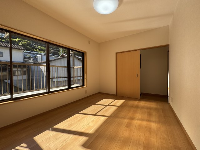 高知市神田の洋室|2階南側6帖洋室を北東から撮影。ドアの向こうはすぐに階段です。左手は南向きバルコニー