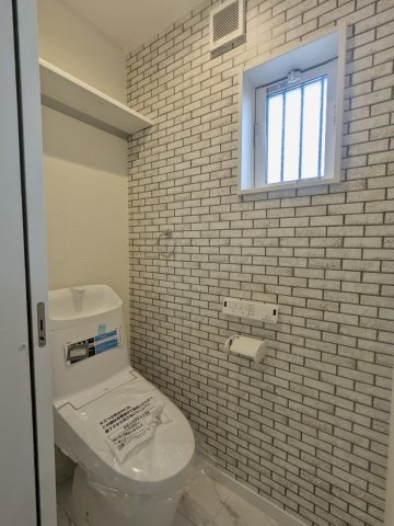 大東市三箇１丁目新築戸建のトイレ|レンガ調のアクセントクロスがおしゃれなトイレ。温水洗浄便座完備で快適に使えます。