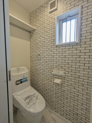 【トイレ】 | 大東市三箇１丁目新築戸建 | レンガ調のアクセントクロスがおしゃれなトイレ。温水洗浄便座完備で快適に使えます。