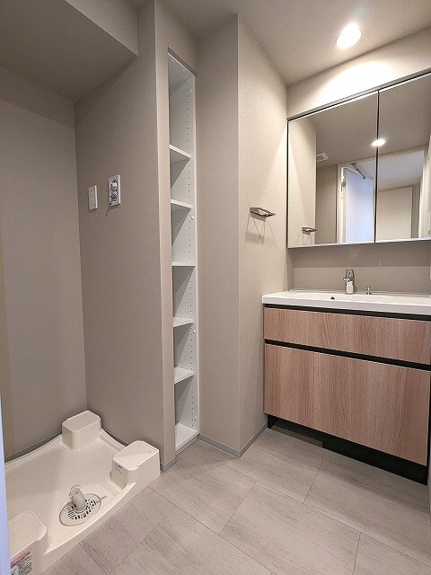JMFレジデンス蔵前二丁目の洗面所|トイレと独立した洗面室、2面鏡、右下にヘルスメーターストック、お手入れし様に排水口を手前中央に配置し、足高の防水パンです