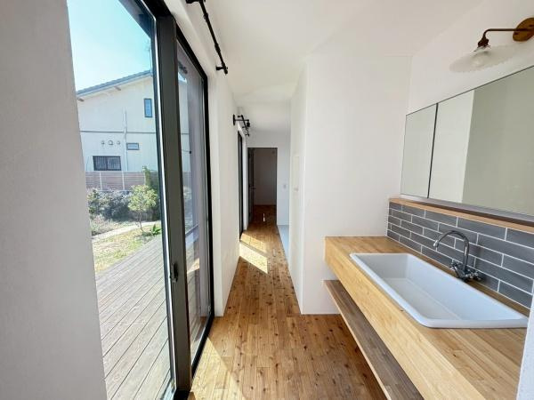 【独立洗面台】 | ●南埼玉郡宮代町東・戸建● | ナチュラルな木目調の床が魅力的な洗面所です。大きな窓からはたっぷりの光が差し込みます。広々とした空間は使いやすさを感じさせます。清潔感のあるシンプルなデザインが特徴です。