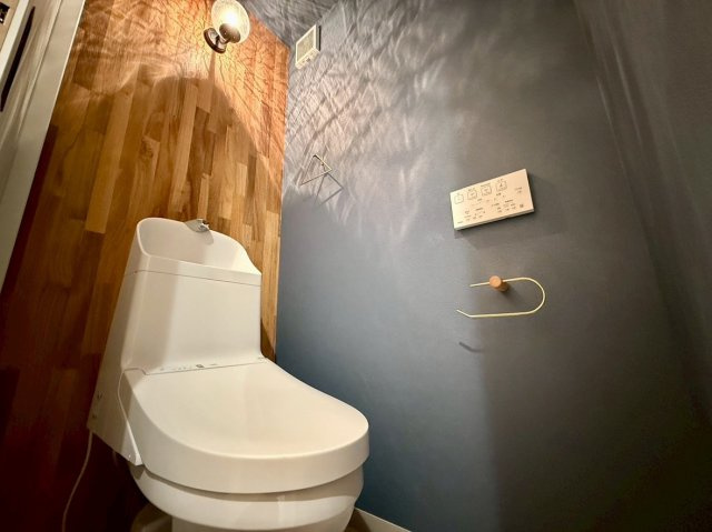 大津市竜が丘　天然木フルリノベーションのトイレ|ネイビーのクロスで落ち着く空間になっています。（TOTOのトイレです）