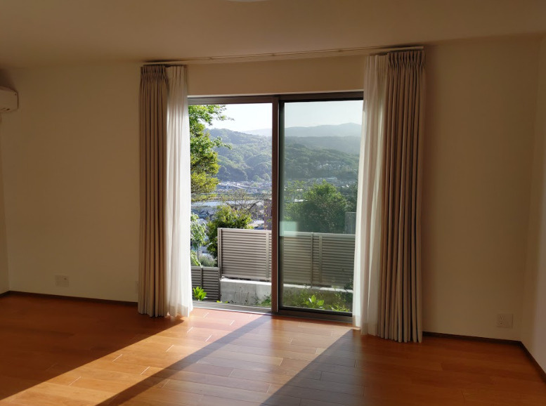 売中古戸建　伊豆の国市大仁の居間・リビング|大きい窓から入るたっぷりの日差しが嬉しいですね。カーテンが天上付けなのですっきりと
した印象です。