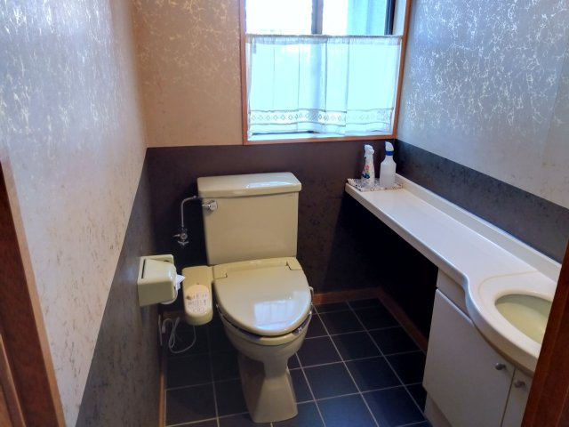 売住付店舗　三島市東大場2丁目のトイレ|居住スペースのトイレです。ブラウンと白のクロスで高級感のある室内です。手洗い場も併設しているので衛生的です。収納もあるのでトイレットペーパーのストックも置けます。